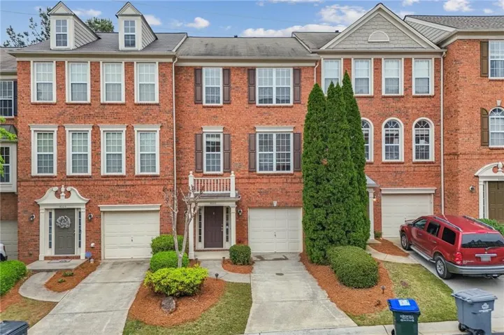 Brick exterior featuring multiple windows with shutters and dormers
