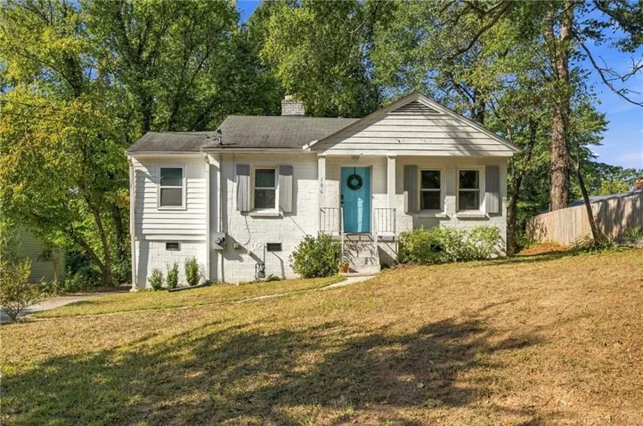 White painted brick exterior with siding accents, a bright blue front door, and a covered entry porch