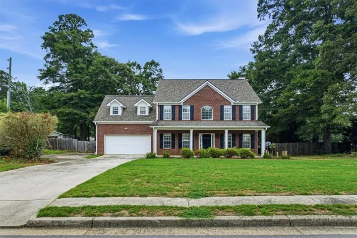 Brick facade with a covered front porch featuring white columns