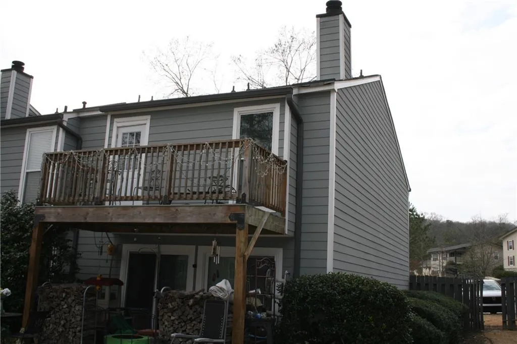Back of property with a chimney and a deck