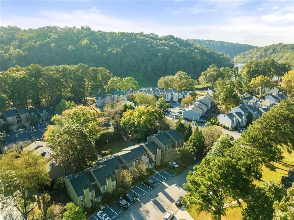View of property location featuring a heavily wooded area and nearby suburban area