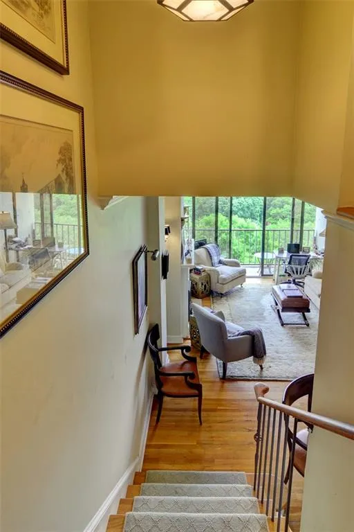 Stairway with a high ceiling, healthy amount of natural light, wood finished floors, and baseboards