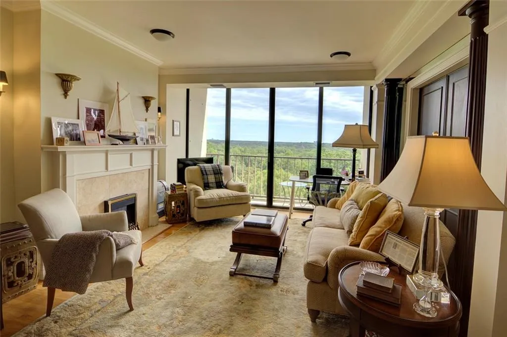 Living area with ornamental molding, wood finished floors, and a tile fireplace