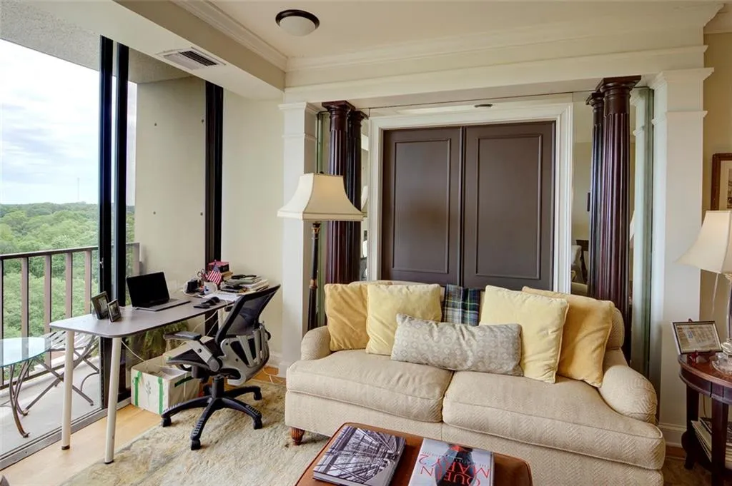 Office with decorative columns, wood finished floors, and ornamental molding