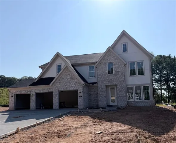 Contemporary exterior with a brick and vertical siding facade, multiple gabled rooflines, a covered entry, and a two-car garage