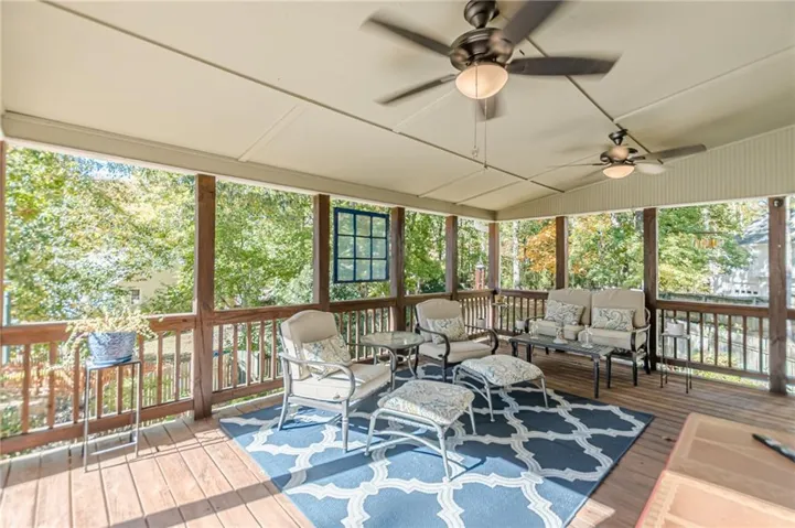 Sunroom with an outdoor hangout area, lofted ceiling, ceiling fan, and a wooden deck