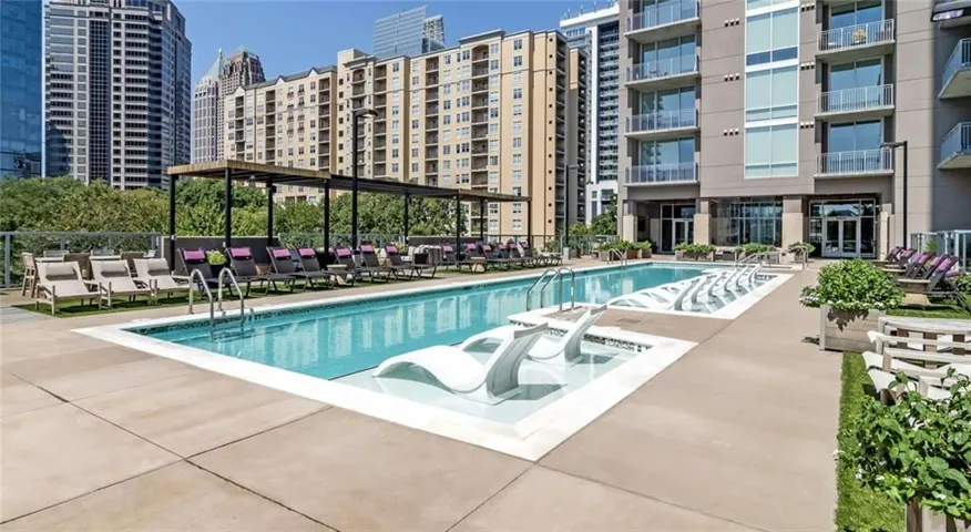 Outdoor pool with integrated lounge seating, surrounding patio, and planted borders