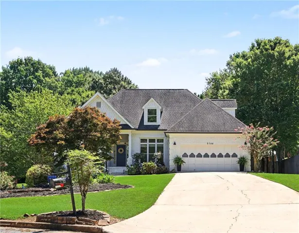 White brick exterior with dark shingle roofing