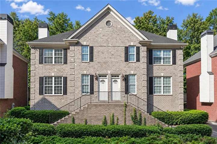 Brick exterior featuring black shutters, a gabled roof