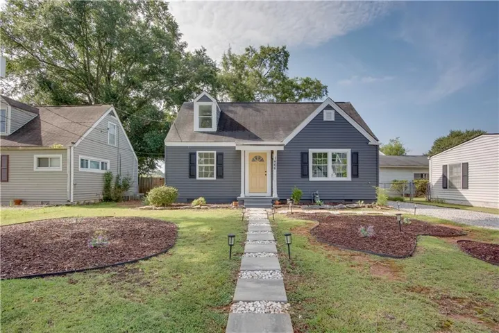 Siding exterior with dormer window, contrasting shutters, and a yellow front door