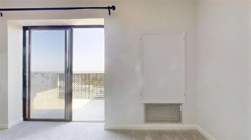 Unfurnished room featuring light carpet and baseboards