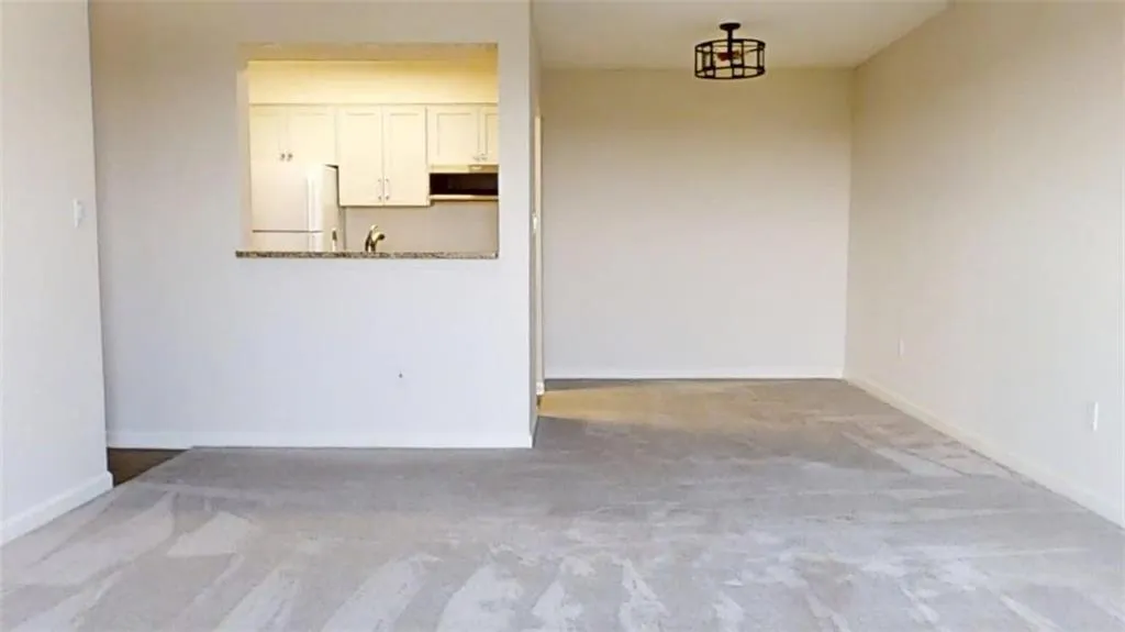 Unfurnished dining area with baseboards and carpet flooring
