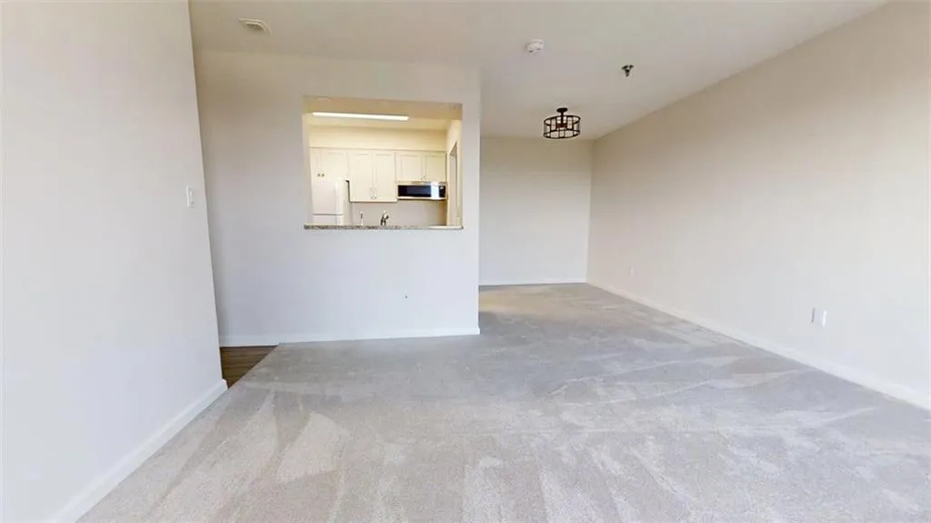 Unfurnished living room with carpet and baseboards