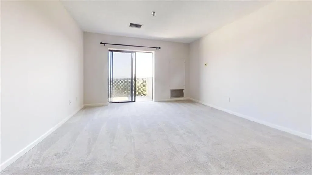 Unfurnished room with light carpet and a pendent fire sprinkler