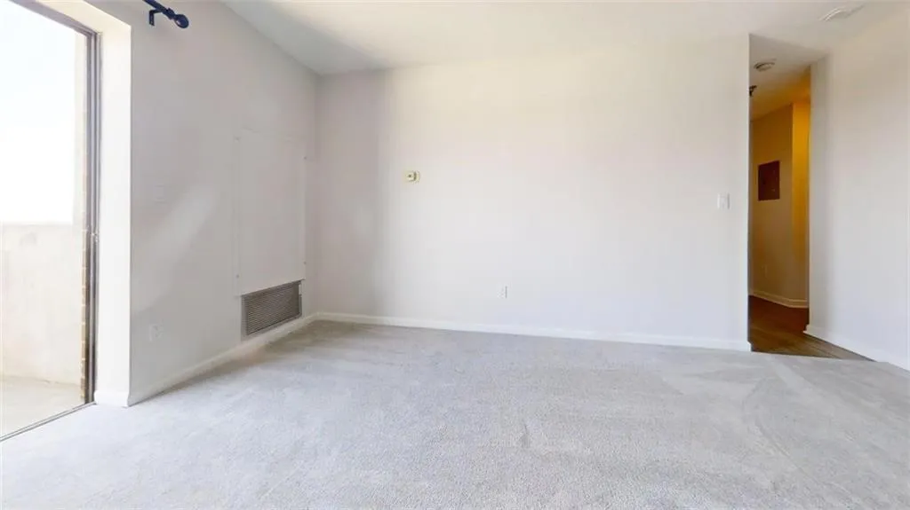 Empty room with light carpet and baseboards