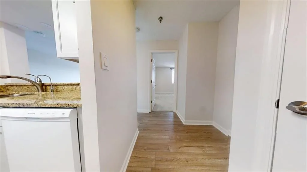 Hallway with a sink and light wood-style floors