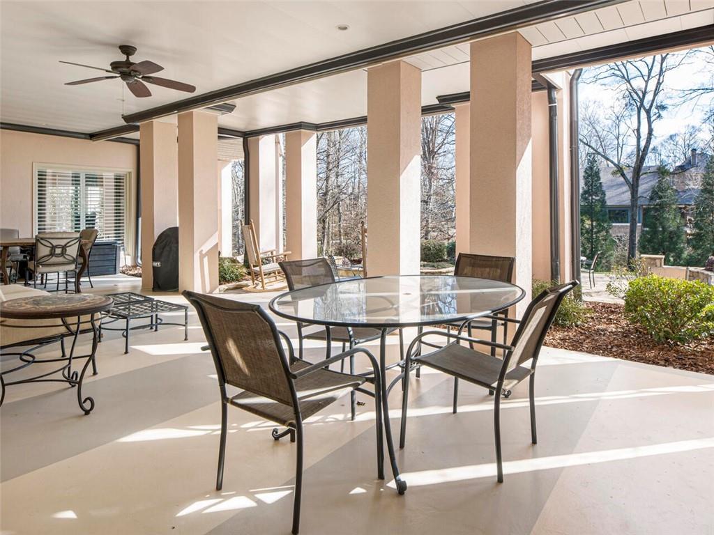 Covered patio area with multiple seating/eating areas overlooking the beautiful gardens
