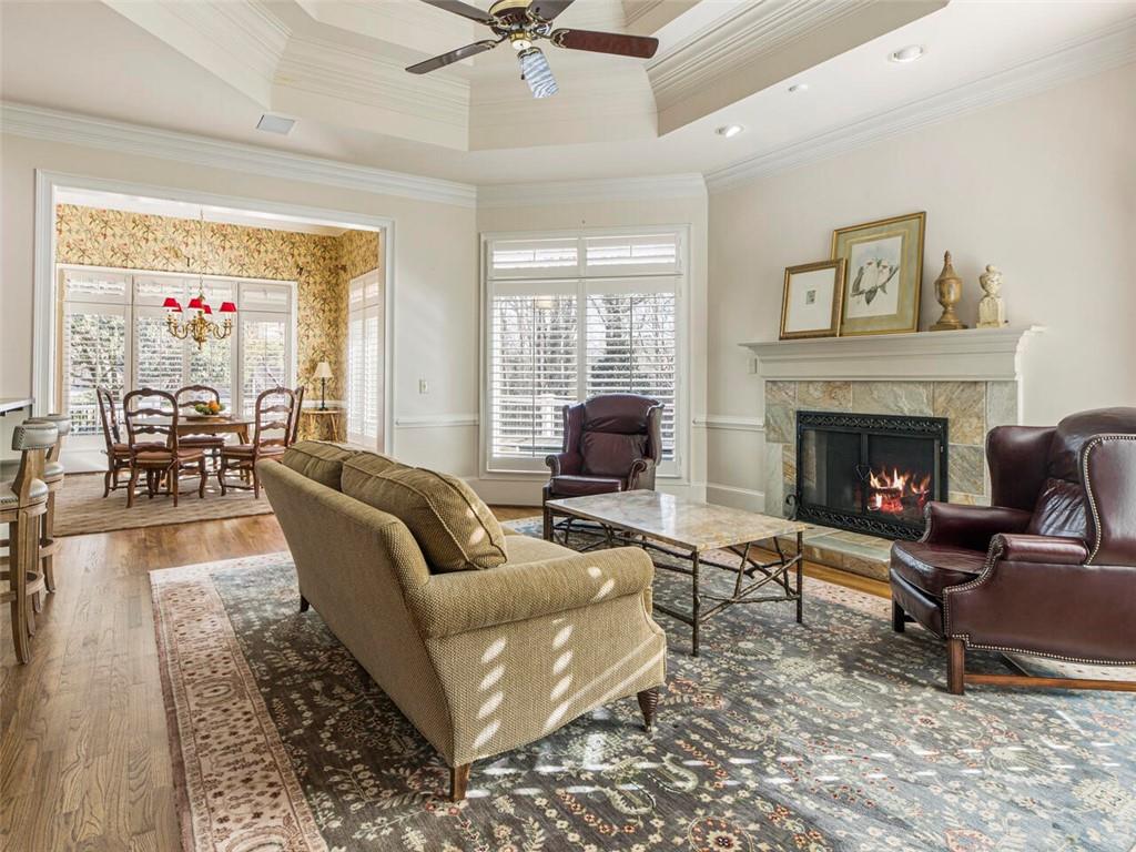 View to keeping room with trey ceiling and fireplace