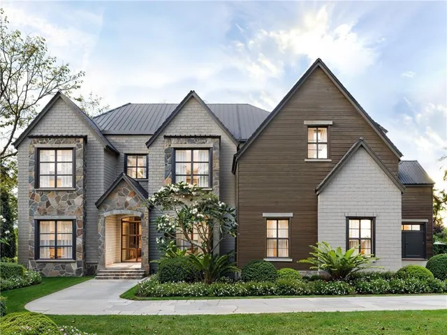 Multi-level exterior with stone accents, dark metal roofing, and a prominent arched entry