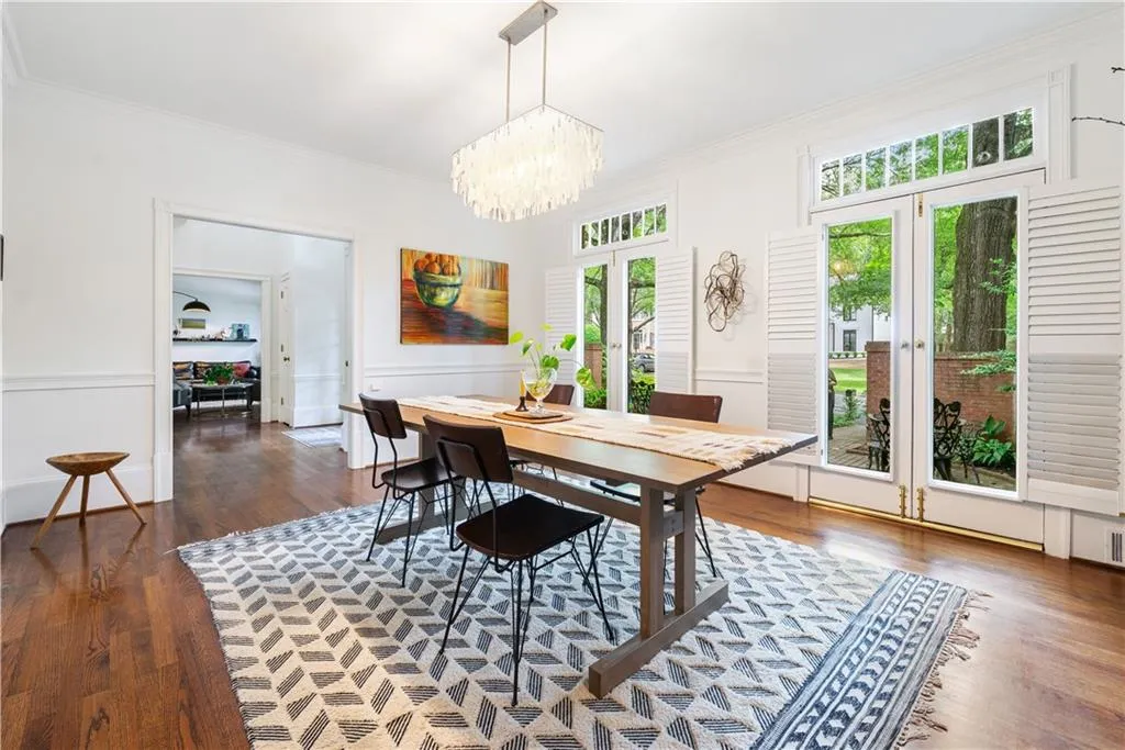 Dining room featuring french doors, ornamental molding, dark wood-style flooring, and a chandelier