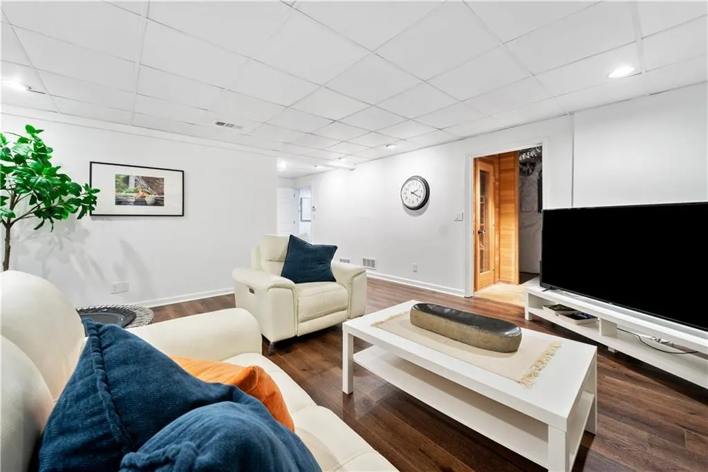 Family room with dark wood-type flooring and a paneled ceiling