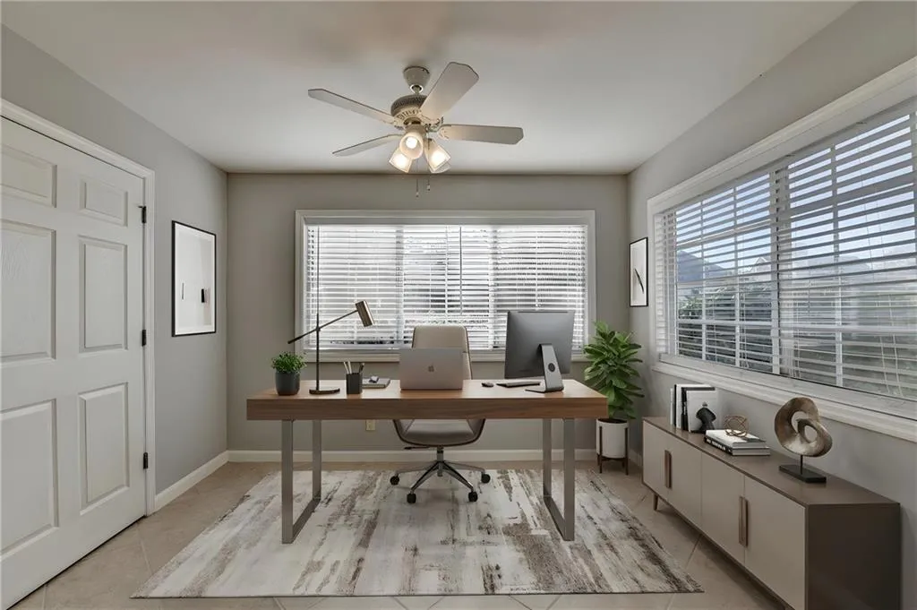 Office space with ceiling fan and light tile patterned flooring