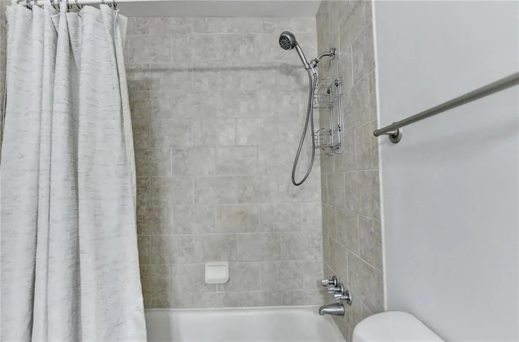 Full bath featuring shower / tub combo and toilet