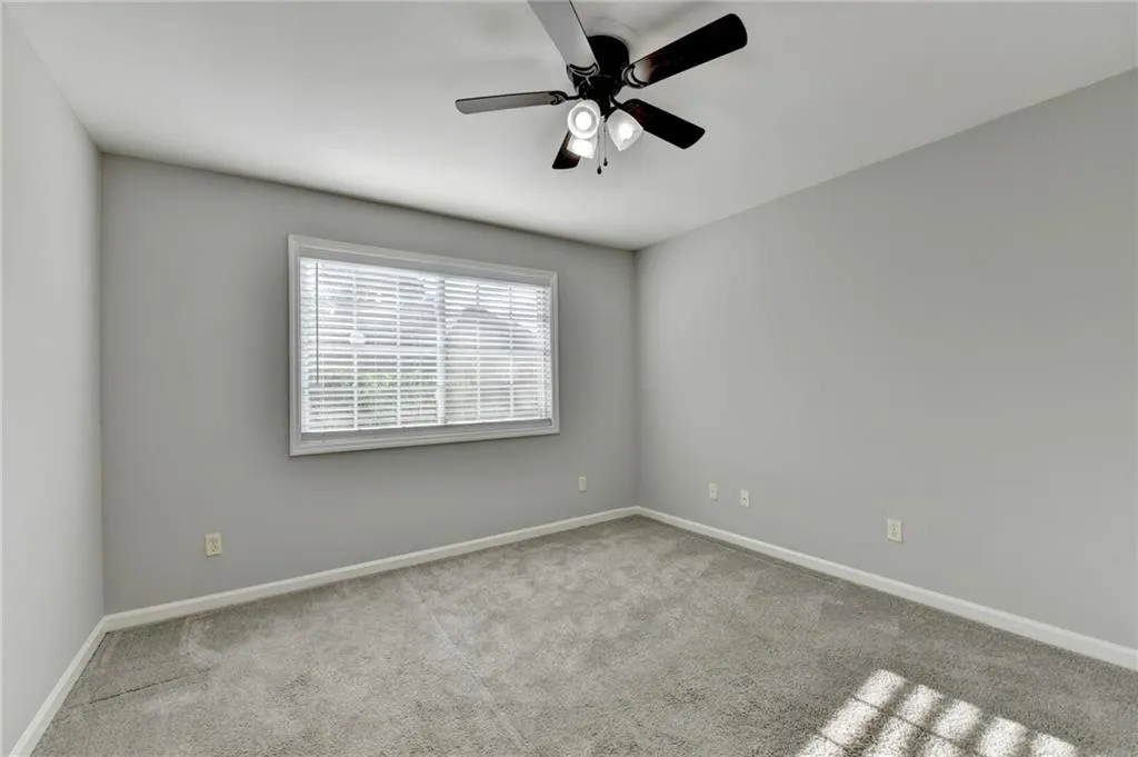 Spare room with light carpet and ceiling fan