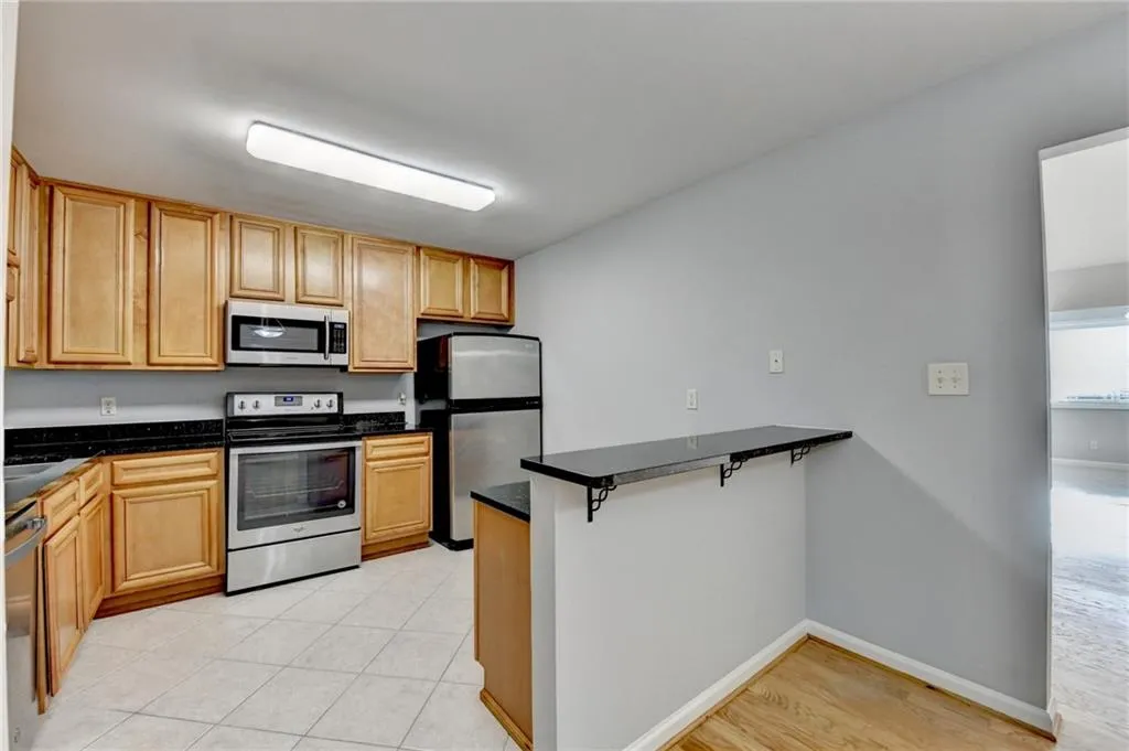 Kitchen with stainless steel appliances, a kitchen bar, and a peninsula