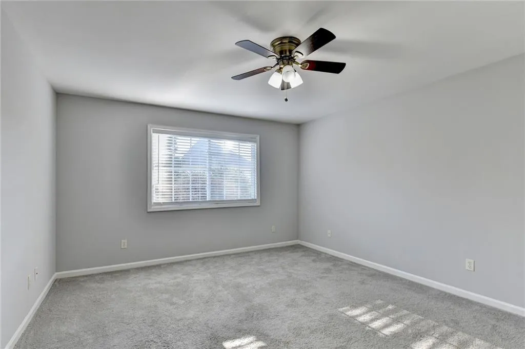 Unfurnished room with light colored carpet and ceiling fan