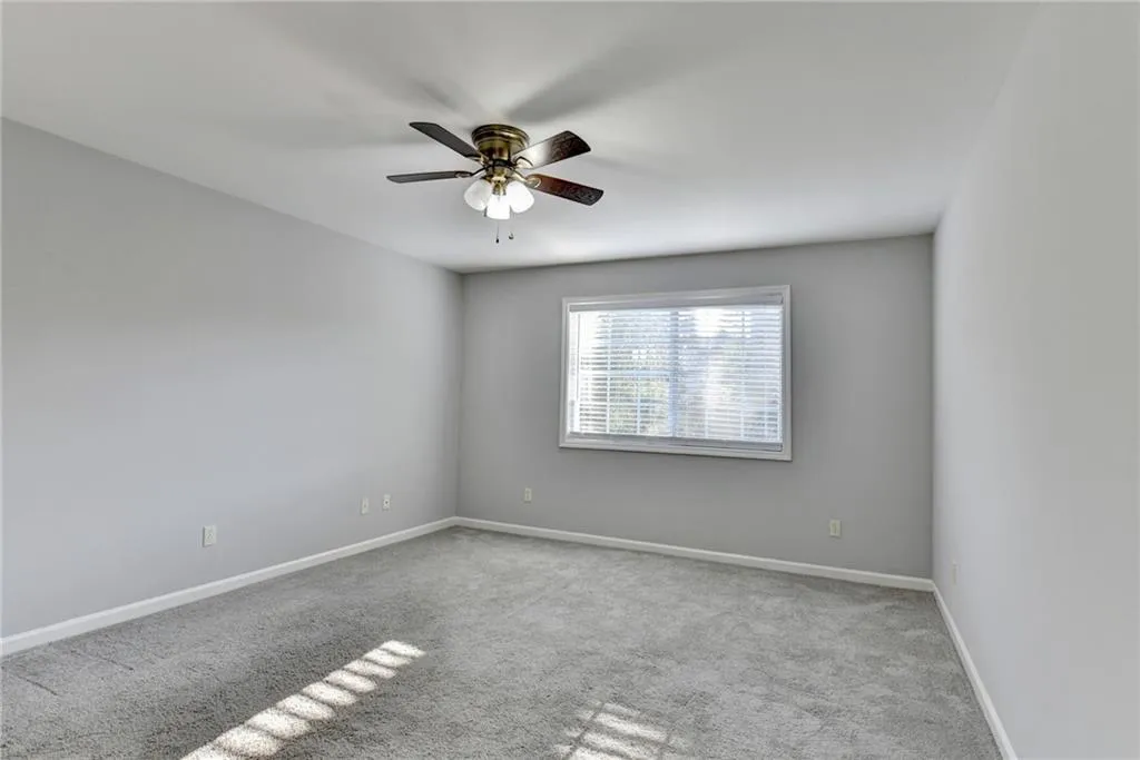 Unfurnished room with carpet flooring and a ceiling fan