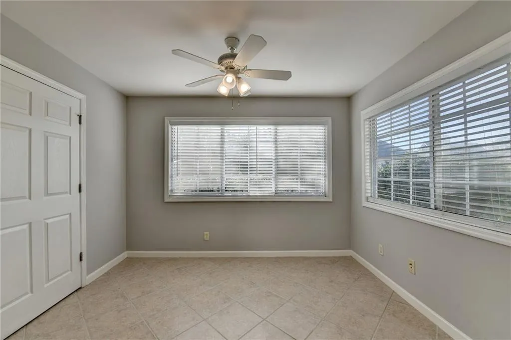 Unfurnished bedroom with a ceiling fan and light tile patterned flooring