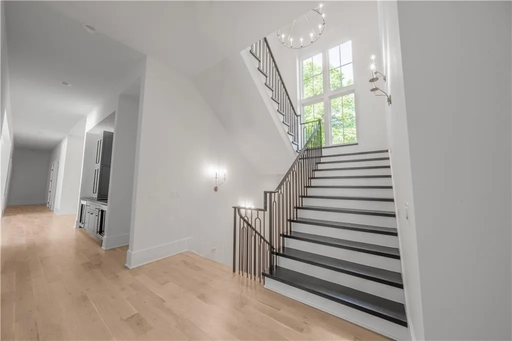 Stairs featuring hardwood / wood-style flooring and an inviting chandelier