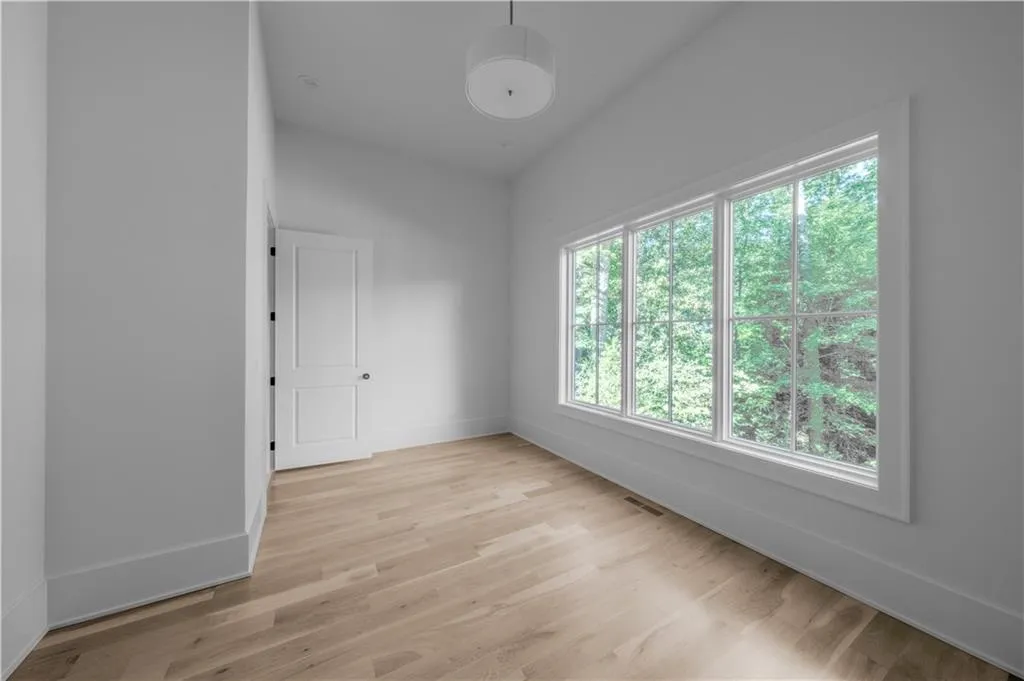 Empty room featuring lofted ceiling and light wood-type flooring
