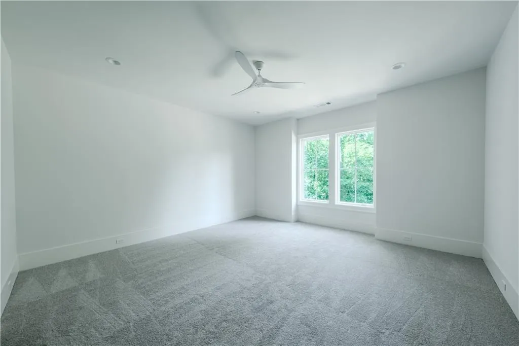 Unfurnished room with ceiling fan and carpet floors