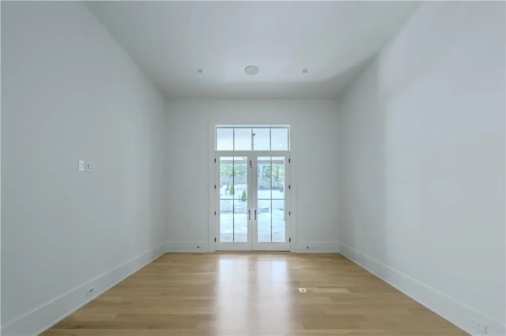 Empty room featuring french doors and light hardwood / wood-style flooring