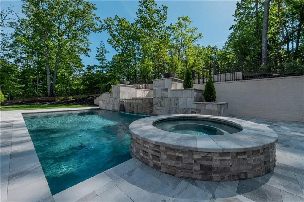 View of swimming pool featuring an in ground hot tub