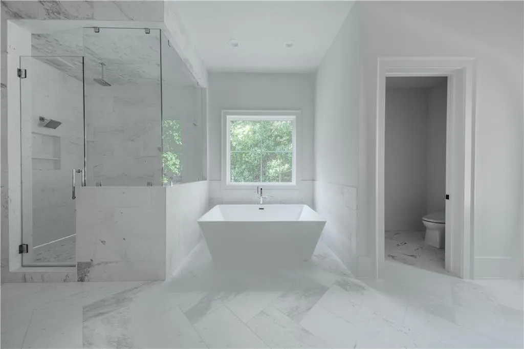 Bathroom featuring toilet, tile walls, and independent shower and bath