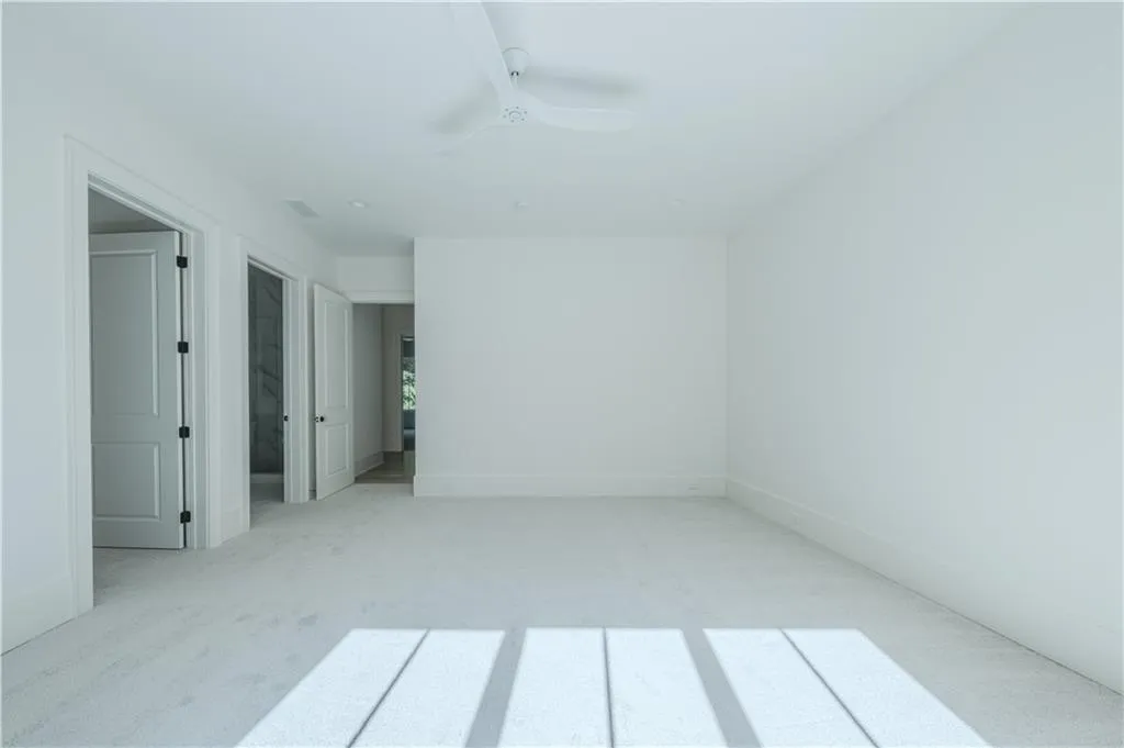 Carpeted spare room with ceiling fan