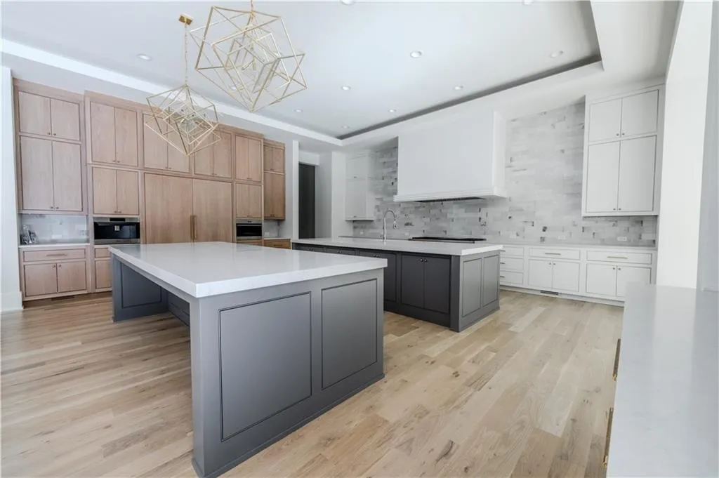 Kitchen with white cabinets, pendant lighting, gray cabinets, and a kitchen island