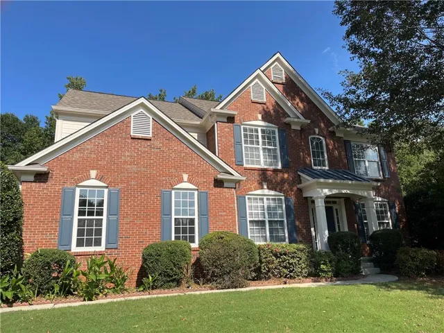 View of front of property featuring brick siding and a front lawn