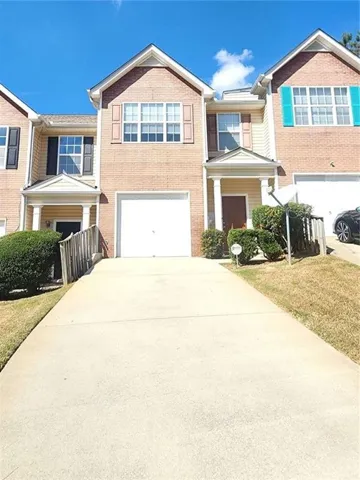 Brick exterior with light-colored siding accents, white garage door, and a concrete driveway