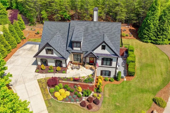 Craftsman-style home featuring a dark gray shingle roof, light-colored siding, and dark trim details