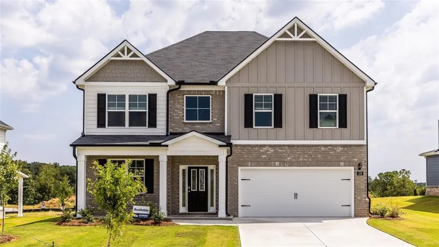 Stone and siding exterior with a covered entry, black front door, and an attached two-car garage