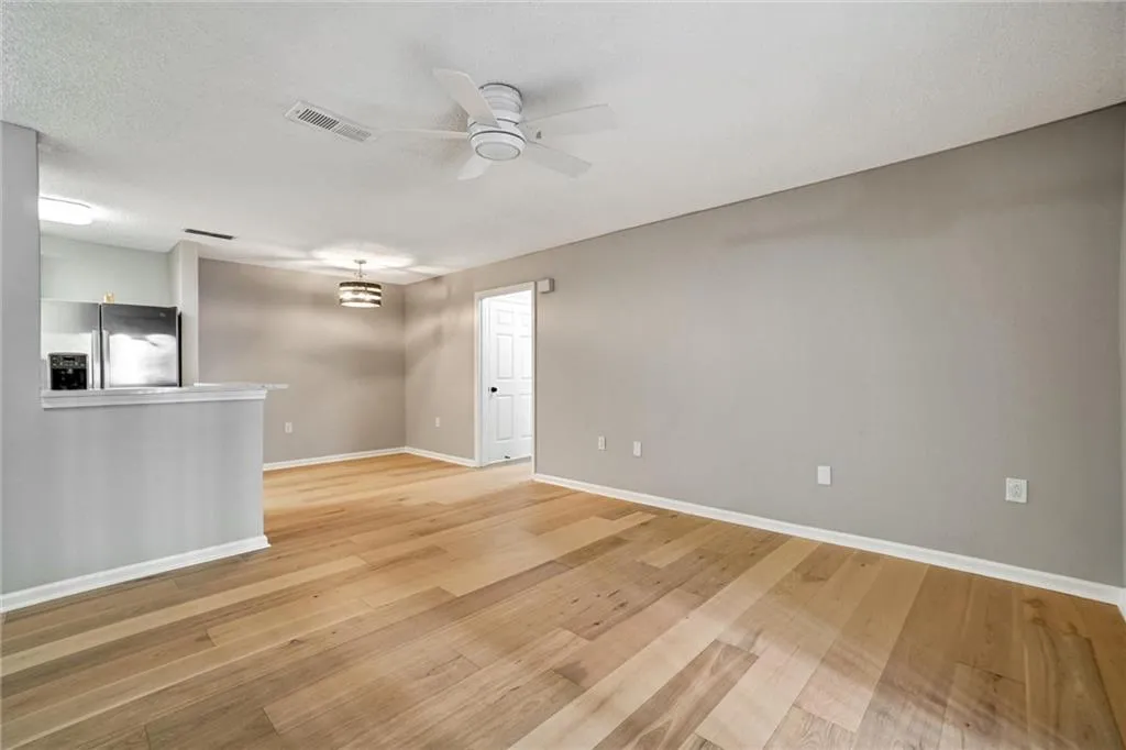Unfurnished room featuring light wood finished floors, a textured ceiling, and a ceiling fan