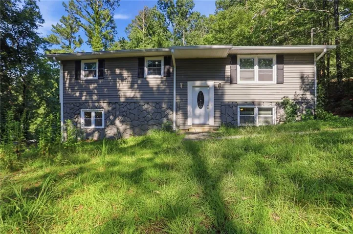 Exterior siding with stone-finish accents and multiple windows