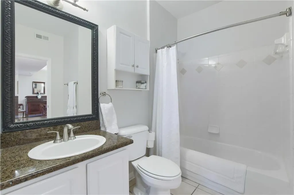 Full bath with shower / bath combination with curtain, vanity, and tile flooring