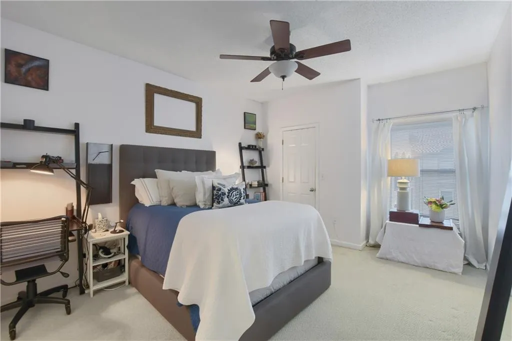 Carpeted bedroom with ceiling fan