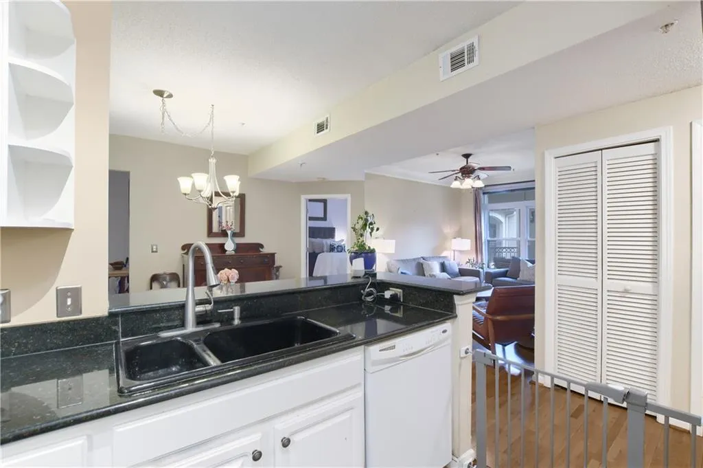 Kitchen with open shelves, white dishwasher, ceiling fan, white cabinetry, and open floor plan