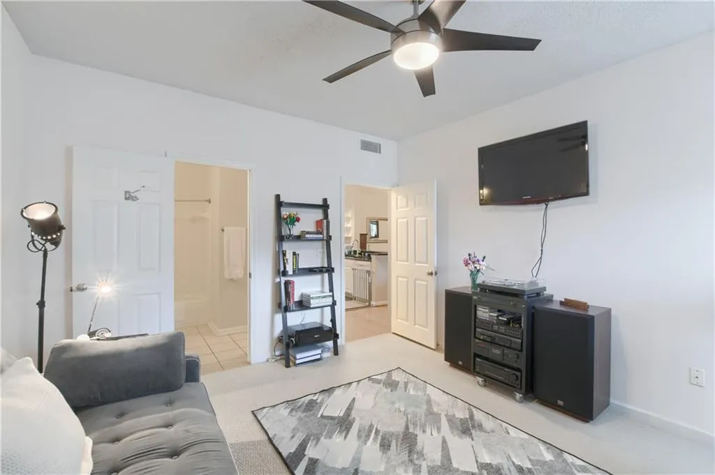 Bedroom with ceiling fan, and light colored carpet